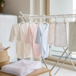 明るい室内で水通ししたベビー服とガーゼを間隔を空けて干す様子